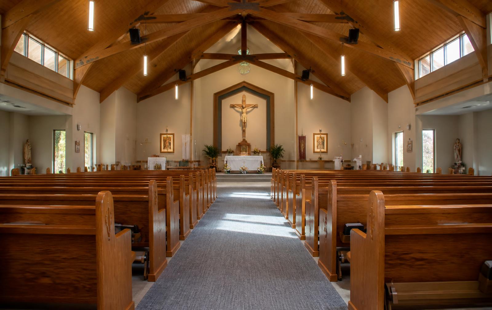 Clean, well-lit sanctuary with polished pews and spotless centre aisle, reset and ready before a service